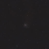 Messier 101 as a faint spiral galaxy in a wide star field