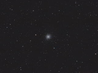 Messier 13 as a bright globular cluster surrounded by stars